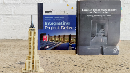 Empire State Building in front of books about Takt time scientific background